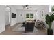 Staged living room with hardwood floors, ceiling fan, and large windows offers a welcoming space at 815 Goshen St, Oxford, NC 27565