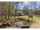 Beautiful backyard featuring a serene pond, mature trees, and a charming house with a porch at 85 Rolling Cloud Dr, Louisburg, NC 27549