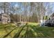 Expansive backyard with mature trees, a fire pit, and a deck, offering a peaceful outdoor retreat at 85 Rolling Cloud Dr, Louisburg, NC 27549