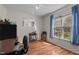 Sunlit bedroom with hardwood floors, a mirror, and large window with peaceful outdoor views at 85 Rolling Cloud Dr, Louisburg, NC 27549