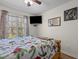 Bright bedroom featuring a large window, modern entertainment and nature-inspired decor for a peaceful ambiance at 85 Rolling Cloud Dr, Louisburg, NC 27549