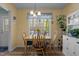 Bright dining area with a large window, wooden table and chairs, and views of the backyard at 85 Rolling Cloud Dr, Louisburg, NC 27549