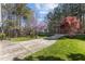Long driveway leading to a home surrounded by mature trees and landscaping, offering privacy and curb appeal at 85 Rolling Cloud Dr, Louisburg, NC 27549