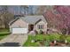 Charming single-story home with an attached garage, lovely front yard, and delightful landscaping at 85 Rolling Cloud Dr, Louisburg, NC 27549