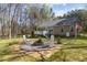 Backyard with a fire pit, deck and lush greenery, perfect for relaxation and outdoor entertaining at 85 Rolling Cloud Dr, Louisburg, NC 27549