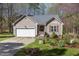 Inviting home with a two-car garage and a lovely front garden, creating a welcoming atmosphere at 85 Rolling Cloud Dr, Louisburg, NC 27549