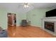Cozy living room with hardwood floors and a fireplace, open to adjacent rooms, with a ceiling fan at 85 Rolling Cloud Dr, Louisburg, NC 27549