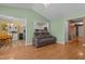 Open-concept living room with hardwood floors, showing view into kitchen and hall, with plenty of seating at 85 Rolling Cloud Dr, Louisburg, NC 27549