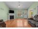 Bright living room with hardwood floors, a fireplace, and a ceiling fan for comfortable living at 85 Rolling Cloud Dr, Louisburg, NC 27549