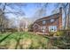 Lush backyard featuring a brick home exterior, a patio with seating, and a sprawling lawn at 1005 Brookview Dr, Elon, NC 27244