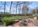 Backyard with brick patio, mature trees, and a designated fire pit area for outdoor enjoyment at 1005 Brookview Dr, Elon, NC 27244