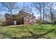 Expansive backyard of a brick home, showcasing a well-maintained lawn and mature trees at 1005 Brookview Dr, Elon, NC 27244