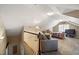 This large bonus room is carpeted and has a bed, sofa, TV, and stairs at 1005 Brookview Dr, Elon, NC 27244