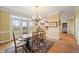 Sunny dining area with rustic wood table, chandelier, and patio access to the backyard at 1005 Brookview Dr, Elon, NC 27244