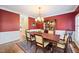 Elegant dining room features a chandelier, wooden table, and rich red walls with white trim at 1005 Brookview Dr, Elon, NC 27244