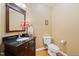 Convenient half bathroom boasts a dark vanity with a granite countertop and a framed mirror at 1005 Brookview Dr, Elon, NC 27244