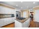 Bright kitchen with stainless steel refrigerator and center island with cooktop and granite counters at 1005 Brookview Dr, Elon, NC 27244