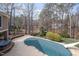 Backyard covered swimming pool with slide surrounded by mature trees and black metal fence at 111 San Juan Dr, Chapel Hill, NC 27514
