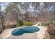 Backyard covered swimming pool with slide surrounded by mature trees and black metal fence at 111 San Juan Dr, Chapel Hill, NC 27514