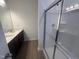 Bathroom featuring a double sink vanity with dark cabinets and a glass-enclosed shower at 11778 Salers Loop, Middlesex, NC 27557