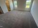 Large bedroom featuring two windows for natural light and neutral carpeting at 11778 Salers Loop, Middlesex, NC 27557