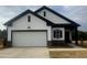New construction home with a white façade, black trim, and a two-car garage at 11778 Salers Loop, Middlesex, NC 27557