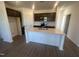 Modern kitchen with stainless steel appliances, a center island with sink, and granite countertops at 11778 Salers Loop, Middlesex, NC 27557