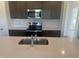 Close-up of kitchen island featuring stainless steel sink, stainless steel appliances, and marble backsplash at 11778 Salers Loop, Middlesex, NC 27557