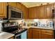 Functional kitchen featuring stainless steel appliances, countertop accessories, and wood cabinetry at 11821 Fairlie Pl, Raleigh, NC 27613