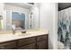 Well-lit bathroom featuring vanity, decorative mirror, and shower with patterned curtain at 120 Renee Dr, Wilson's Mills, NC 27577