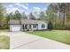 Well-kept single-story home featuring an attached garage, long driveway, and lush green front yard at 120 Renee Dr, Wilson's Mills, NC 27577