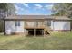Back exterior of a home with wooden deck and stairs overlooking a level backyard at 120 Renee Dr, Wilson's Mills, NC 27577