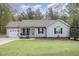 Inviting single-story home with a charming front porch, attached garage, and well-manicured lawn at 120 Renee Dr, Wilson's Mills, NC 27577