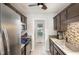 Galley kitchen featuring stainless steel appliances, dark cabinets, and a mosaic tile backsplash at 120 Renee Dr, Wilson's Mills, NC 27577