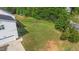 Side view of the home with a well maintained lawn and a wooded area at 1308 Aspen Falls Ct, Willow Springs, NC 27592