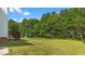 Spacious backyard with lush green lawn and wooded area in the background at 1308 Aspen Falls Ct, Willow Springs, NC 27592
