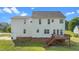 View of home’s rear exterior featuring a wooden deck and lush green yard at 1308 Aspen Falls Ct, Willow Springs, NC 27592