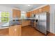 Kitchen features stainless steel appliances, wood cabinets, and hardwood floors at 1308 Aspen Falls Ct, Willow Springs, NC 27592