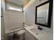 Bright bathroom with a tub shower combo, a white vanity, and black fixtures at 141 Ruskin Dr, Smithfield, NC 27577