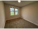 Bright bedroom featuring neutral walls, cozy carpet, and a window offering views of the outdoors at 141 Ruskin Dr, Smithfield, NC 27577