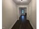 Hallway with dark wood floors leads to a living area with fireplace and large window at 141 Ruskin Dr, Smithfield, NC 27577