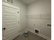 Functional laundry room with neutral paint, tile flooring, shelving and white door at 141 Ruskin Dr, Smithfield, NC 27577