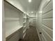 Bright walk-in closet with white shelving, hanging rods, and carpet at 141 Ruskin Dr, Smithfield, NC 27577