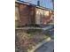 Exterior corner view of red brick home with boarded windows and overgrown landscaping at 1421 Blanton St, Rocky Mount, NC 27803