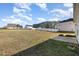 Expansive backyard with lush grass, white fence and neighboring houses under a bright blue sky at 15 Woodworkers Way, Clayton, NC 27520