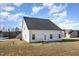 Backyard of a house with well-kept lawn, concrete patio, and white siding under a bright blue sky at 15 Woodworkers Way, Clayton, NC 27520