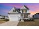 Charming two-story home with a manicured front yard and attached two-car garage and lovely sunset at 15 Woodworkers Way, Clayton, NC 27520