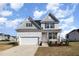 Inviting two-story home with a front-facing garage, landscaped yard, and classic design details at 15 Woodworkers Way, Clayton, NC 27520