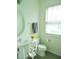 Well-lit half-bathroom features a pedestal sink, a decorative vase, and a window at 1725 Mallard Trace Dr, Wendell, NC 27591