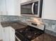 Close-up of kitchen with stainless steel appliances, granite countertops, and modern backsplash at 1725 Mallard Trace Dr, Wendell, NC 27591